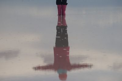 Low section of person standing on wet road