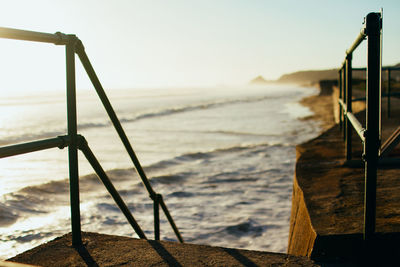 Close-up of railing by sea against sky