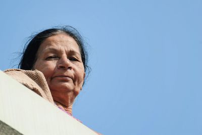 Portrait of senior woman against clear blue sky