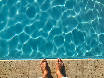 Low section of person legs in swimming pool