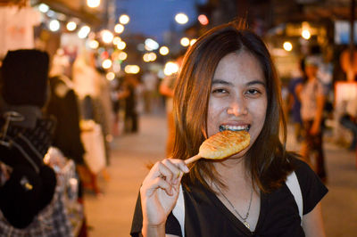 Portrait of woman eating food at restaurant