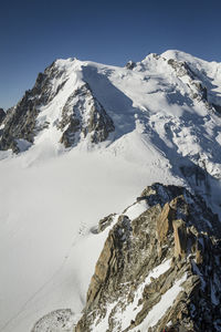 Scenic view of snowcapped mountains against clear sky