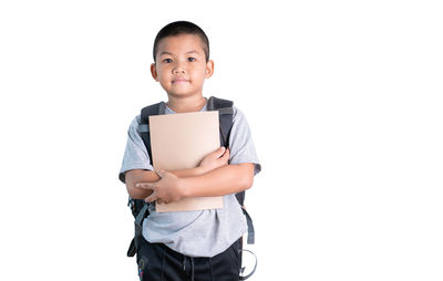 Portrait of smiling boy standing against white background