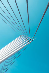 Low angle view of bridge cables against clear blue sky