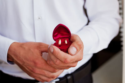 Close-up of man holding wedding rings