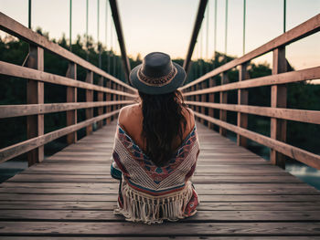 Rear view of woman walking on footbridge