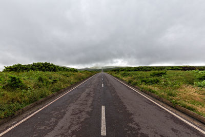 Road amidst trees against sky