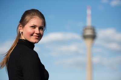 Portrait of smiling young woman with fernsehturm in background