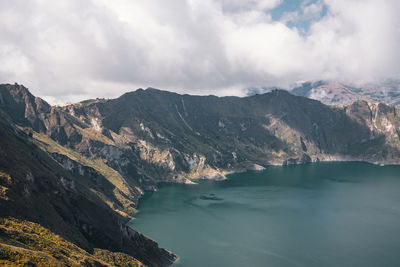 Scenic view of lake by mountains against sky