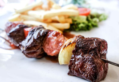 Close-up of grilled meat skewer on table