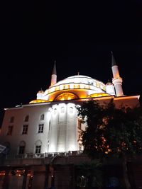 Low angle view of illuminated building against sky at night