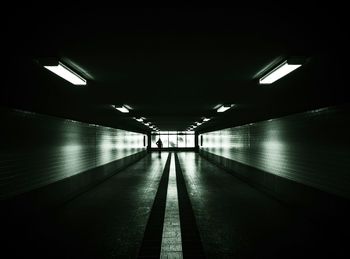 Full length of woman walking in illuminated tunnel