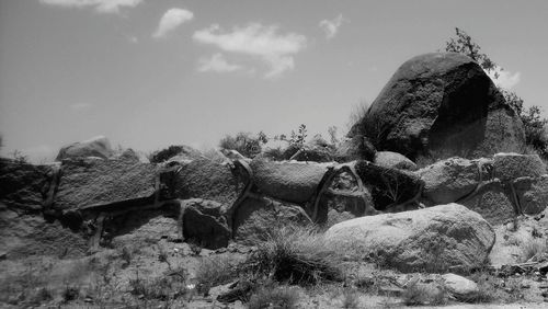 Panoramic shot of rocks on field against sky