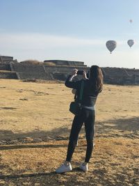 Rear view of woman standing against the sky