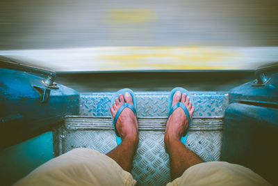 Low section of man standing in train