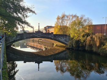 Arch bridge over river against sky