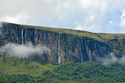 Panoramic shot of trees on land and mountain against sky