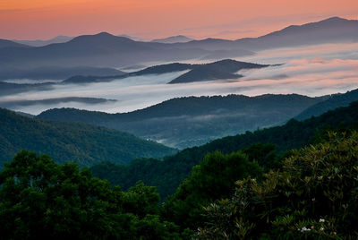 Scenic view of green mountains during sunset