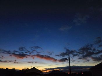 Low angle view of silhouette electricity pylon against sky during sunset