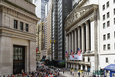 People on street amidst buildings in city