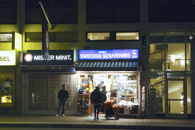 Group of people walking on illuminated road at night