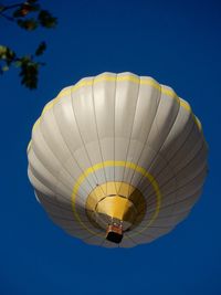 Low angle view of hot air balloon against clear blue sky