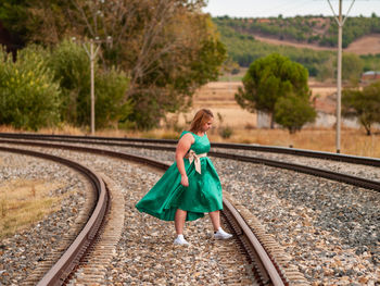 Woman standing on railroad tracks