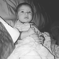 Portrait of cute baby lying on bed at home