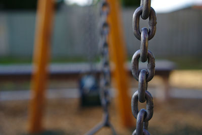 Close-up of chain hanging on metal fence