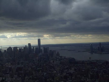 Buildings in city against cloudy sky