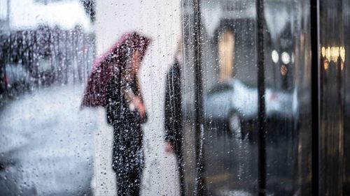 Girl walking on wet glass window in rainy season