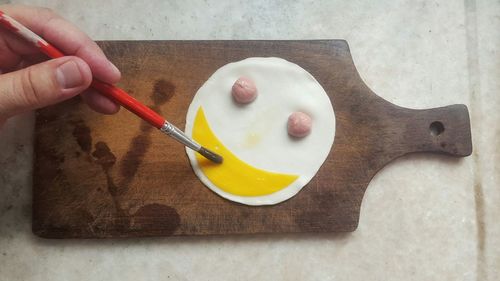 Close-up of hand holding ice cream on table