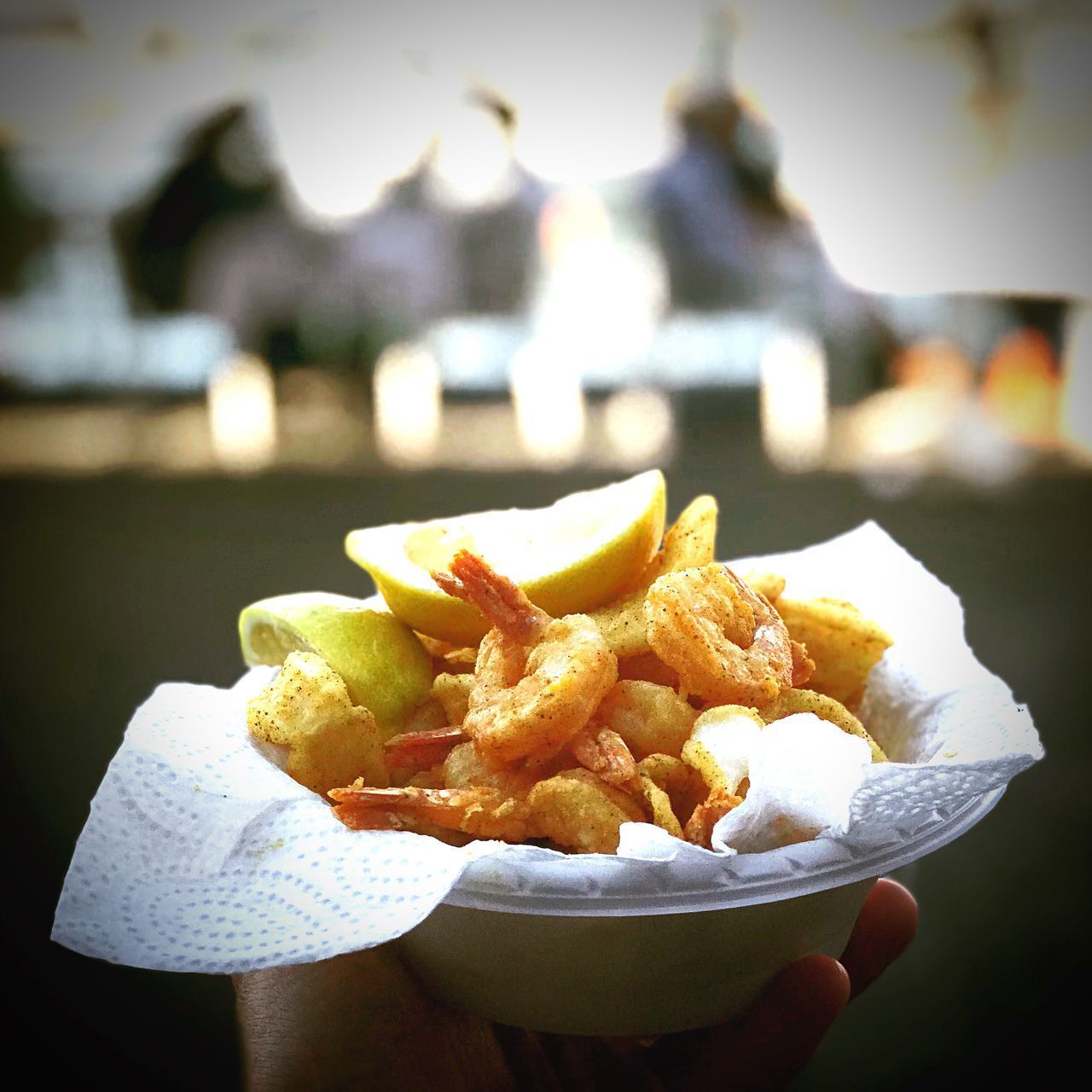 CLOSE-UP OF HAND HOLDING FOOD ON PLATE