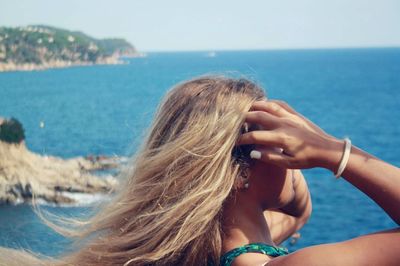 Woman looking at sea against clear sky