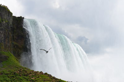 Low angle view of waterfall against sky