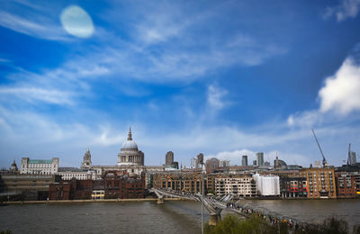 Buildings in city against cloudy sky