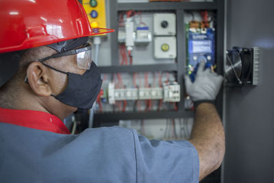 Rear view of man working elevator controle