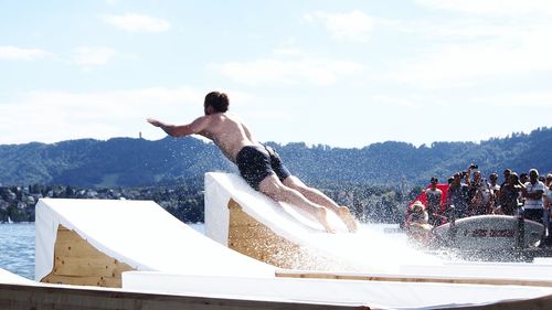 Full length of shirtless man against sky