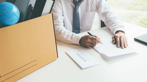 Midsection of real estate agent and colleague working in office