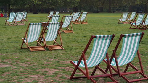 Empty chairs against trees on landscape