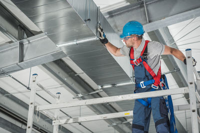 Low angle view of man working at construction site