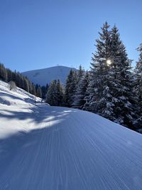 Scenic view of snow covered mountains against clear blue sky