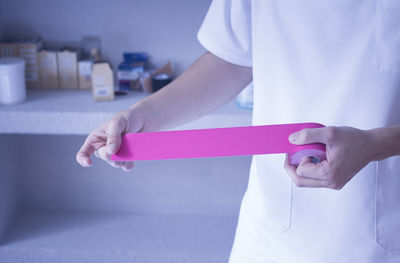 Midsection of woman holding adhesive bandage