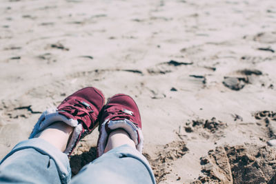 Low section of person wearing shoes on beach