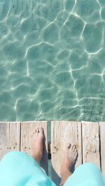 Low section of person relaxing in swimming pool