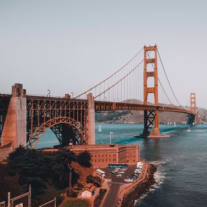 Suspension bridge in city against clear sky