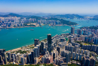 Aerial view of city by sea against sky