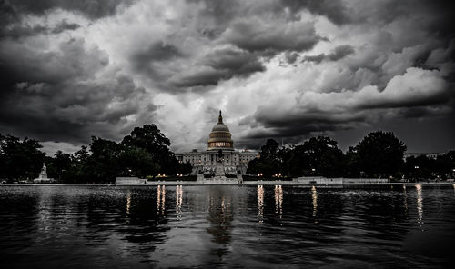 View of buildings in lake against cloudy sky