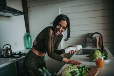 Mid adult woman having food at home