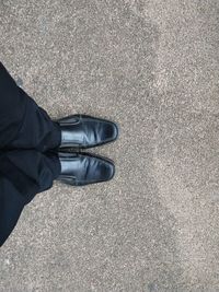 Low section of man standing on road